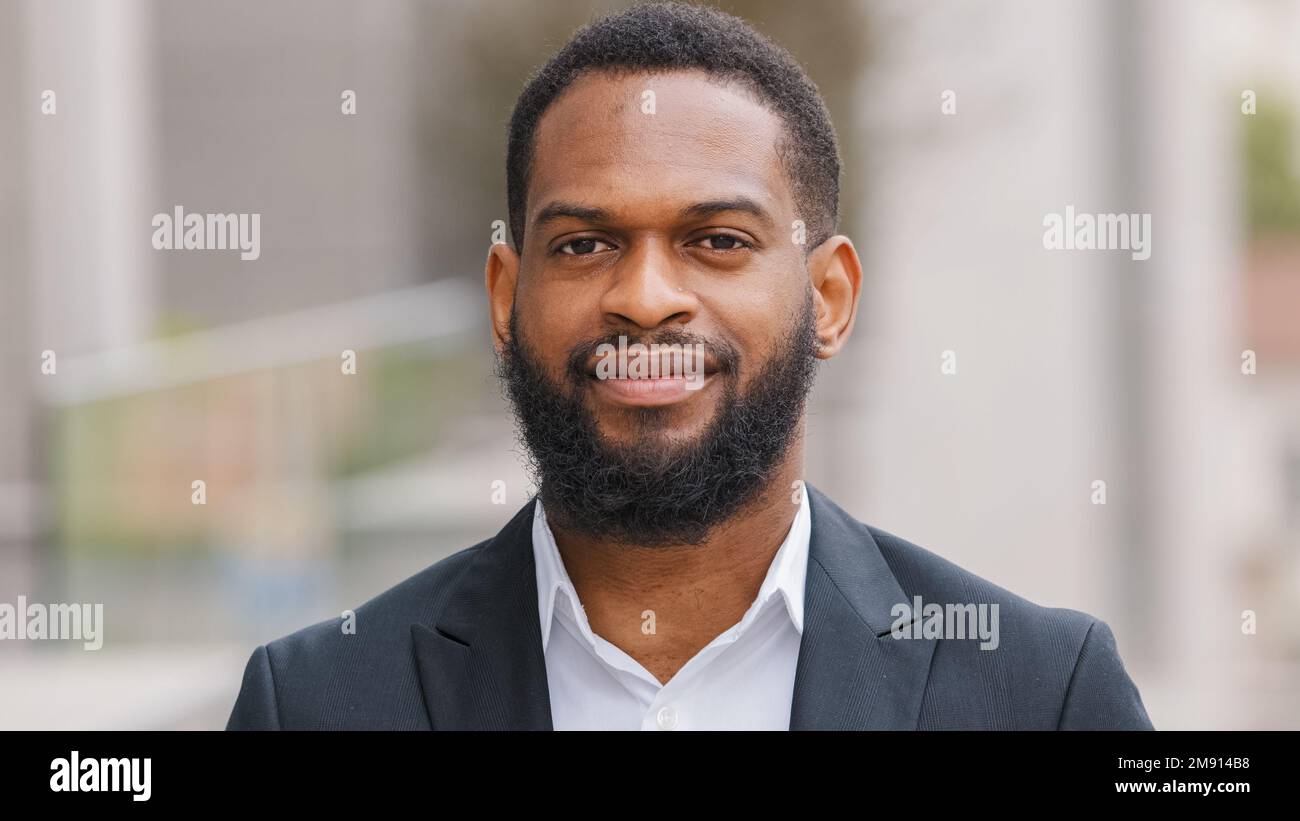 Nahaufnahme männliches Porträt im Freien bärtiger erwachsener, ethnischer, männlicher Büroangestellter in der Stadt lächelnder afroamerikanischer Geschäftsführer eines Unternehmens Stockfoto