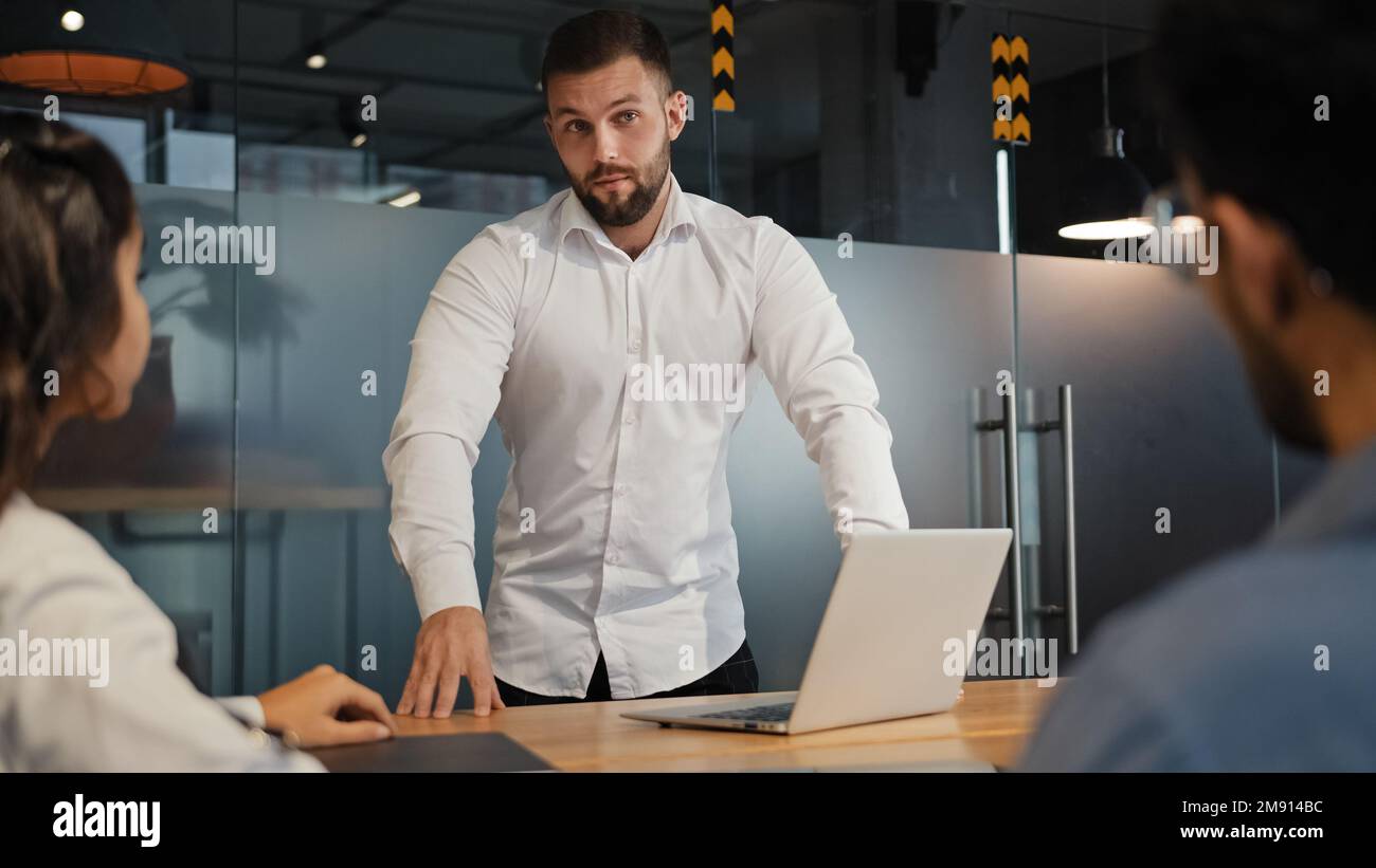 Geschäftsführer des kaukasischen Geschäftsmanns spricht mit Partnern im Büro. Erwachsenenberatung im Gespräch mit multiethnischen Kollegen Stockfoto