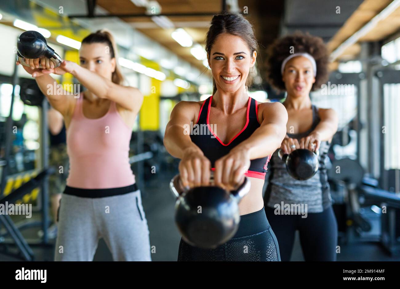 Eine Gruppe von fittigen Menschen, die Hanteln während eines Trainingskurms im Fitnessstudio heben Stockfoto