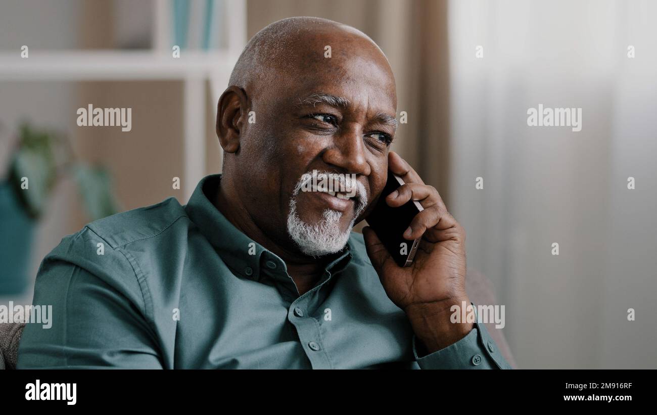 Afrikanischer Geschäftsmann mittleren Alters Senior reifer Geschäftsmann Unternehmer zu Hause im Büro sprechen Telefon chatten mobile Unterhaltung Buchungsauftrag Stockfoto