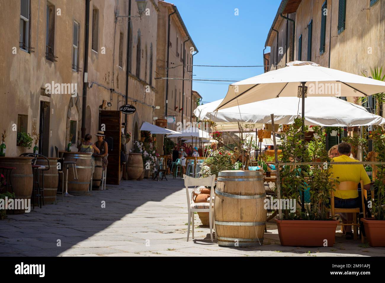 Die Leute essen auf der Straße in einer Altstadt in der Toskana, Italien Stockfoto