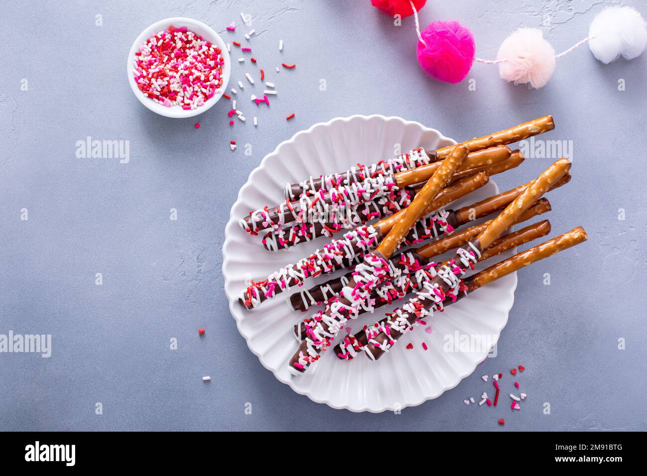 Valentinsgeschenk, mit Schokolade überzogene Brezelstangen mit Streuseln Stockfoto