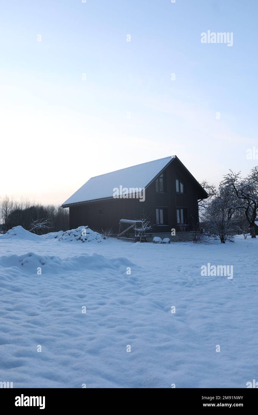 Ein Bauernhaus. Holzhaus in modernem Stil mit großen Fenstern im Winter. Außenansicht, Holzwände Stockfoto