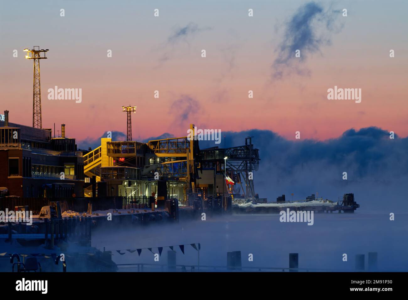 Helsinki, Finnland - 15. Januar 2021: Docks und Terminals des Hafens von Katajanokka an einem extrem kalten Winteraufgang mit aufsteigendem Nebel Stockfoto