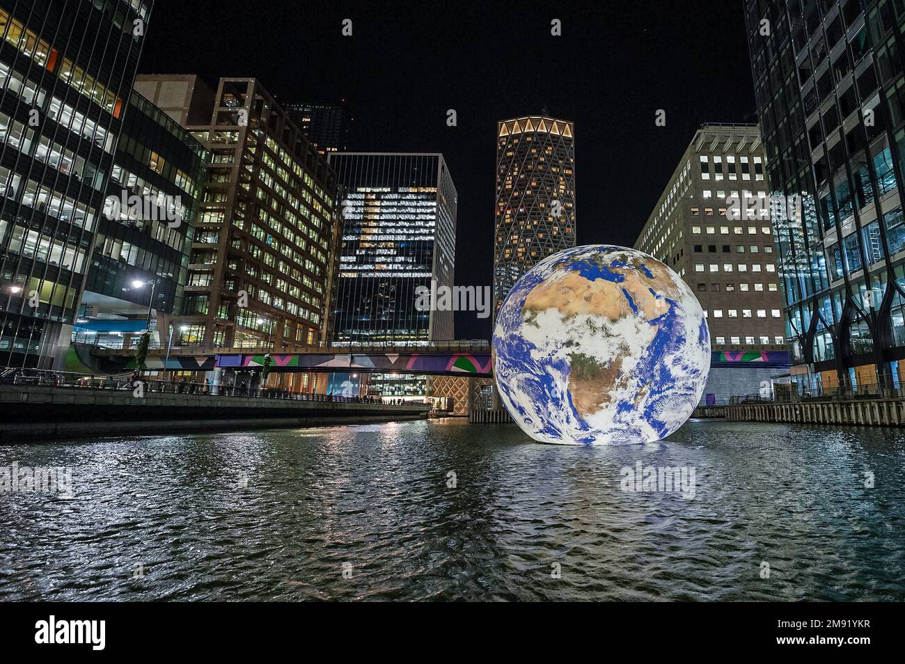 London, Großbritannien. 16. Januar 2023. Floating Earth von Luke Jerram Installation im Middle Dock bei Canary Wharf, Teil des Canary Wharf Winter Lights Festivals. Die monumentale, innen beleuchtete „Gaia“-Skulptur kehrt zum beliebten Winterlichtfestival mit mehreren beleuchteten Installationen in der Gegend zurück. Der britische Künstler Jerram möchte einen „Überblickseffekt“ erzeugen, den Astronauten erleben, wenn sie vom Weltraum aus auf die Erde blicken. Kredit: Guy Corbishley/Alamy Live News Stockfoto