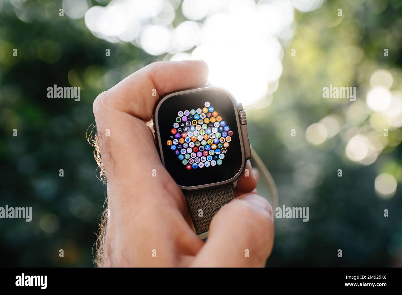 London, Vereinigtes Königreich - 28. September 2022: Männliche Hand hält die neue Apple Watch Ultra Smartwatch vor unscharfem Bokeh-Hintergrund mit Hunderten von Apps auf dem oled-Display mit großartiger Benutzeroberfläche Stockfoto