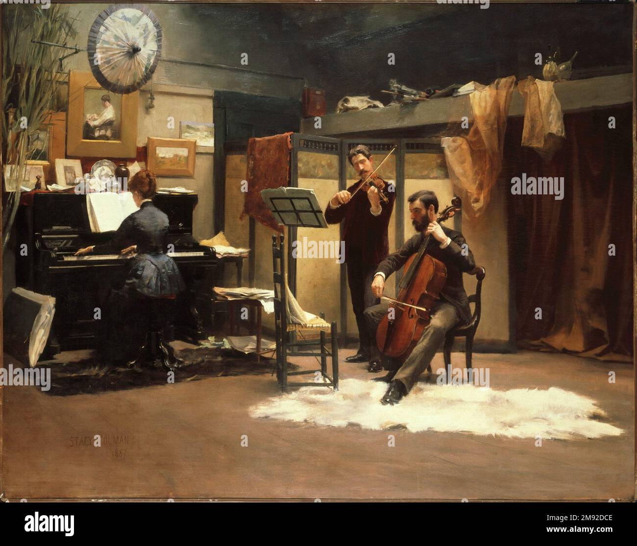 The Musicale Stacy Tolman (Amerikanisch, 1860-1935). Die Musicale, 1887. Öl auf Segeltuch, 36 1/4 x 46 Zoll (92 x 116,9 cm). „Musicales“, gesellschaftliche Abende mit Musik, und ihre Darstellung in Malerei waren im späten 19. Jahrhundert bei den Oberklassen außerordentlich beliebt, da sie daran interessiert waren, ihren Anbau und ihr Engagement für einen künstlerischen Lebensstil zu demonstrieren. Von der typischen Kulisse des Salons verlegte Stacy Tolman das Musical in das Künstlerstudio und verlieh der Szene ein Künstlerambiente. Er stellte sich auch als Violinist vor und beschwörte klassische Vergleiche zwischen Mu Stockfoto