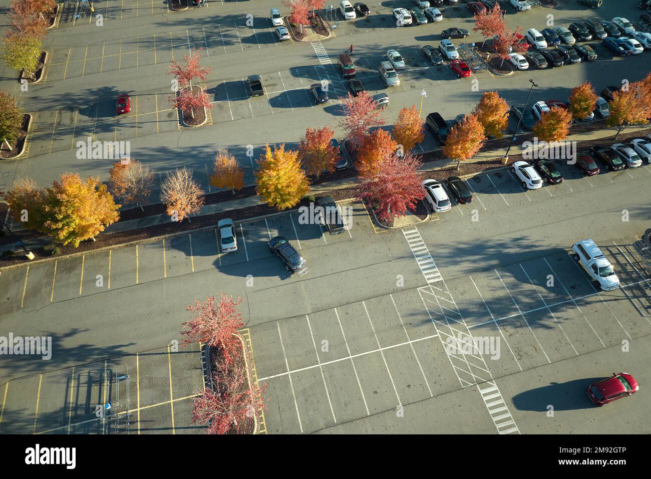 Luftaufnahme vieler farbenfroher Autos, die auf dem Parkplatz geparkt sind, mit Linien und Markierungen für Parkplätze und Wegbeschreibungen. Platz für Fahrzeuge vor einem Stockfoto