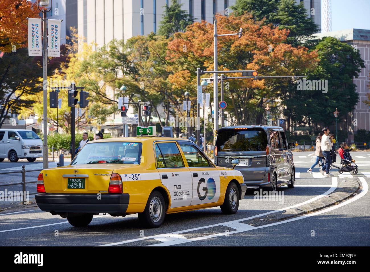 Ein gelbes Taxi wartet an einer Kreuzung in den Straßen von Yokohama Stockfoto