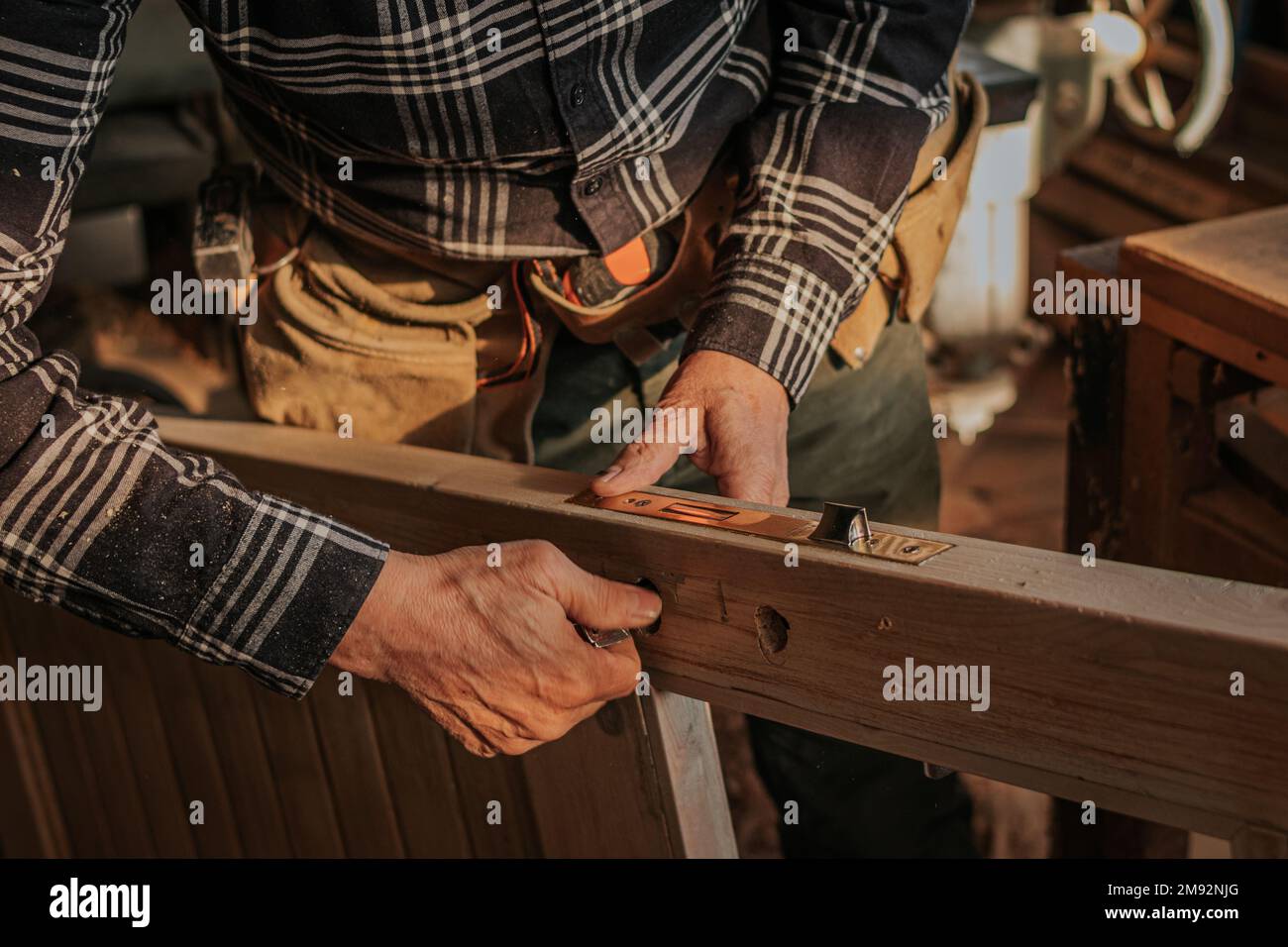 Pflanzen männlicher Holzarbeiter in Freizeitkleidung Arbeiten mit Holztüren während der Herstellung von Holzmustern in Schreinern Stockfoto