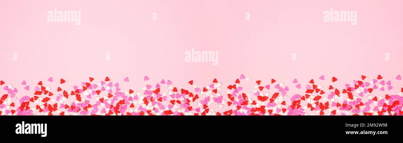 Langes Banner am Valentinstag mit süßem Herzdesign auf pinkfarbenem, strukturiertem Hintergrund. Speicherplatz kopieren. Stockfoto