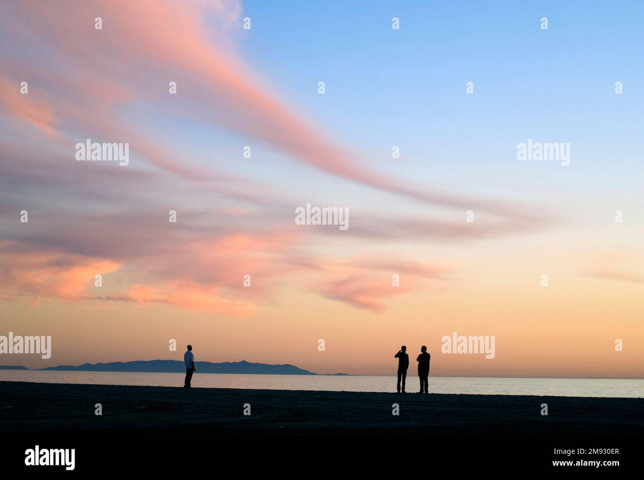 Menschen am Strand bei Sonnenuntergang in Santa Monica mit Blick auf die Palos Verdes Halbinsel Stockfoto
