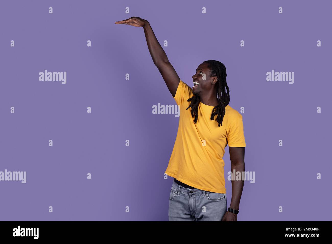 Aufgeregter afroamerikanischer Typ, der etwas Unsichtbares zeigt Stockfoto