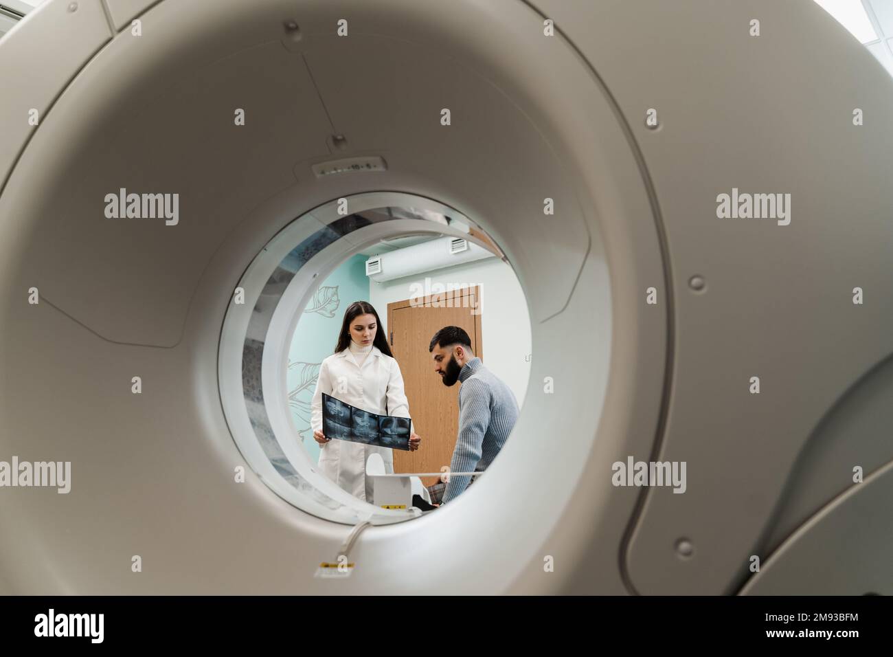 Der MRT-Arzt zeigt ein Röntgenbild des Abdomens eines Patienten. Sprechstunde nach MRT-Untersuchung in der Medizinischen Klinik Stockfoto