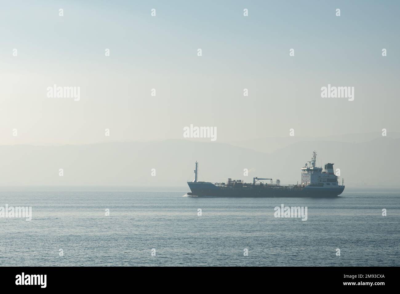 Frachtschiff auf See , Luftaufnahme eines allein fahrenden Frachtschiff auf offener See bei Sonnenaufgang. Stockfoto