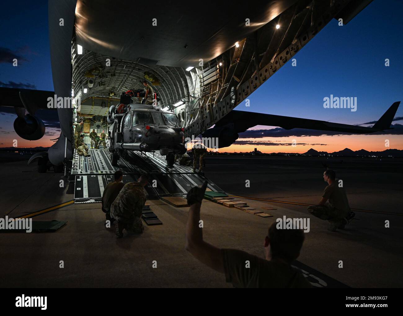 Flieger entladen einen HH-60G Pave Hawk von einem C-17 Globemaster III, der Joint Base Lewis-McCord am Luftwaffenstützpunkt Davis-Monthan, Arizona, zugewiesen ist, 17. Oktober 2022. Der erste von drei HH-60G Pave Hawks, die der 55. Rettungsschwadron zugeteilt wurden, kehrte von einem Einsatz an einen geheimen Ort auf dem Globemaster zurück. Das war der letzte Einsatz, den Davis-Monthan Pave Hawks benutzte. (USA Air Force Foto von Airman 1. Class Paige Weldon) Stockfoto