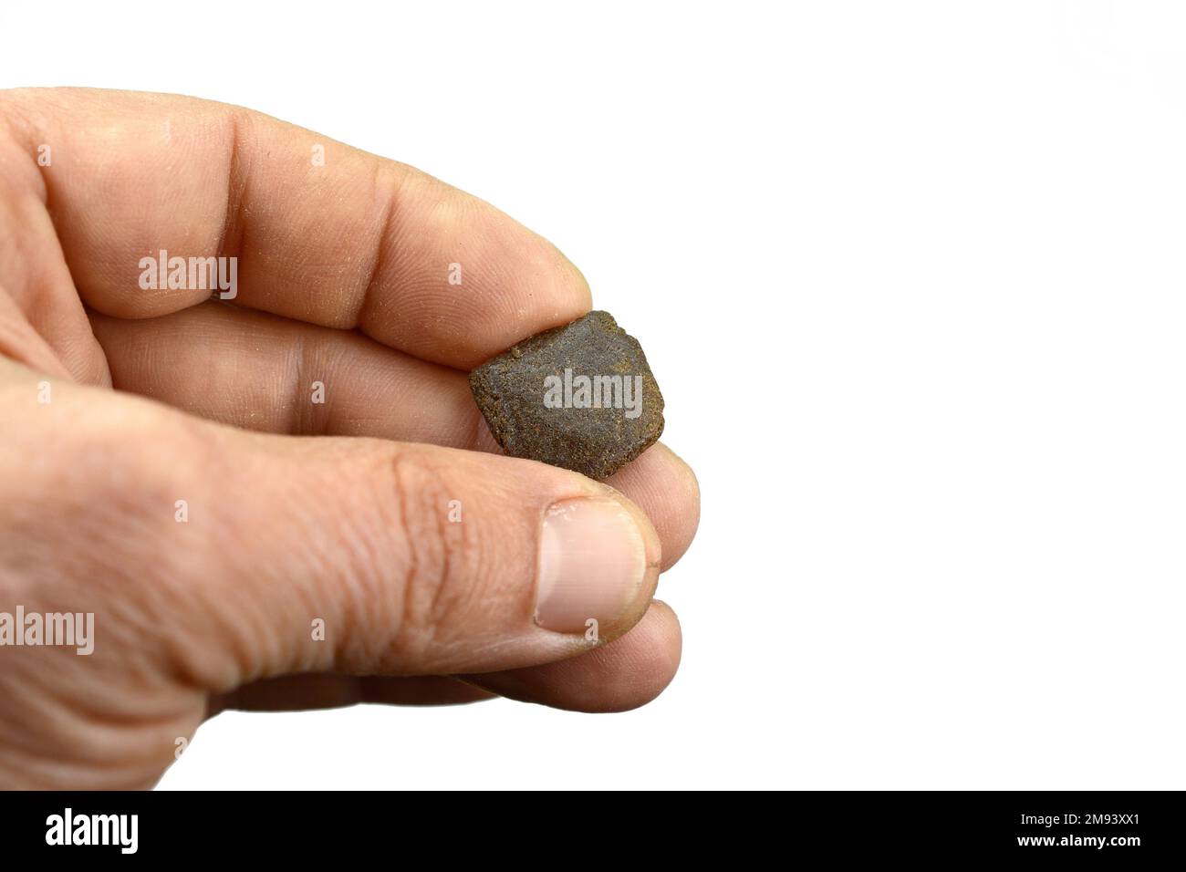 Männliche Hand hält ein Stück hochwertiges Hasch. Medizinische Marihuana-Extraktion Hash Cannabis Pollen Haschisch Stockfoto