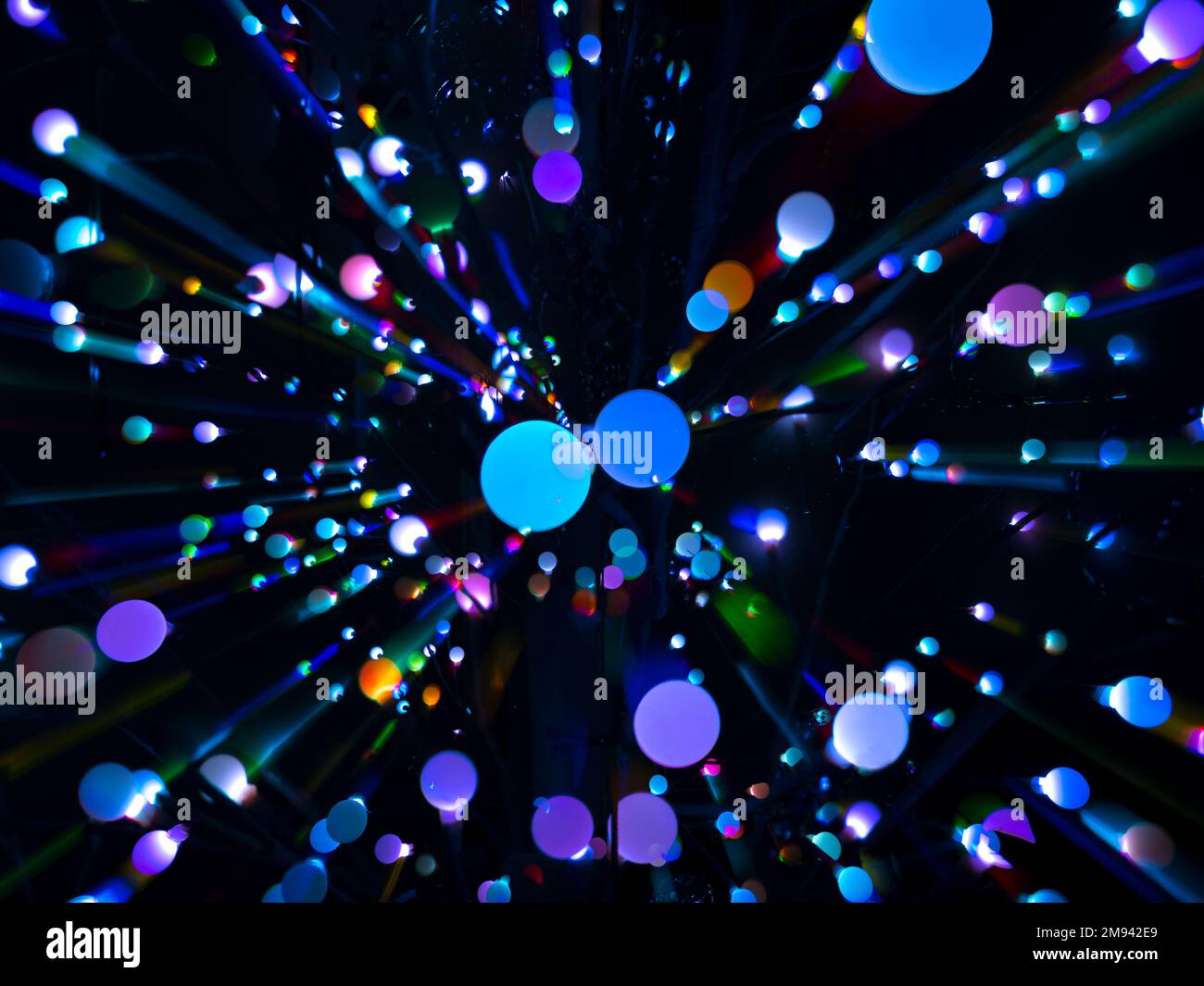 Farbenfrohe abstrakte Kreise in einem strahlenden Muster vor schwarzem Hintergrund Stockfoto