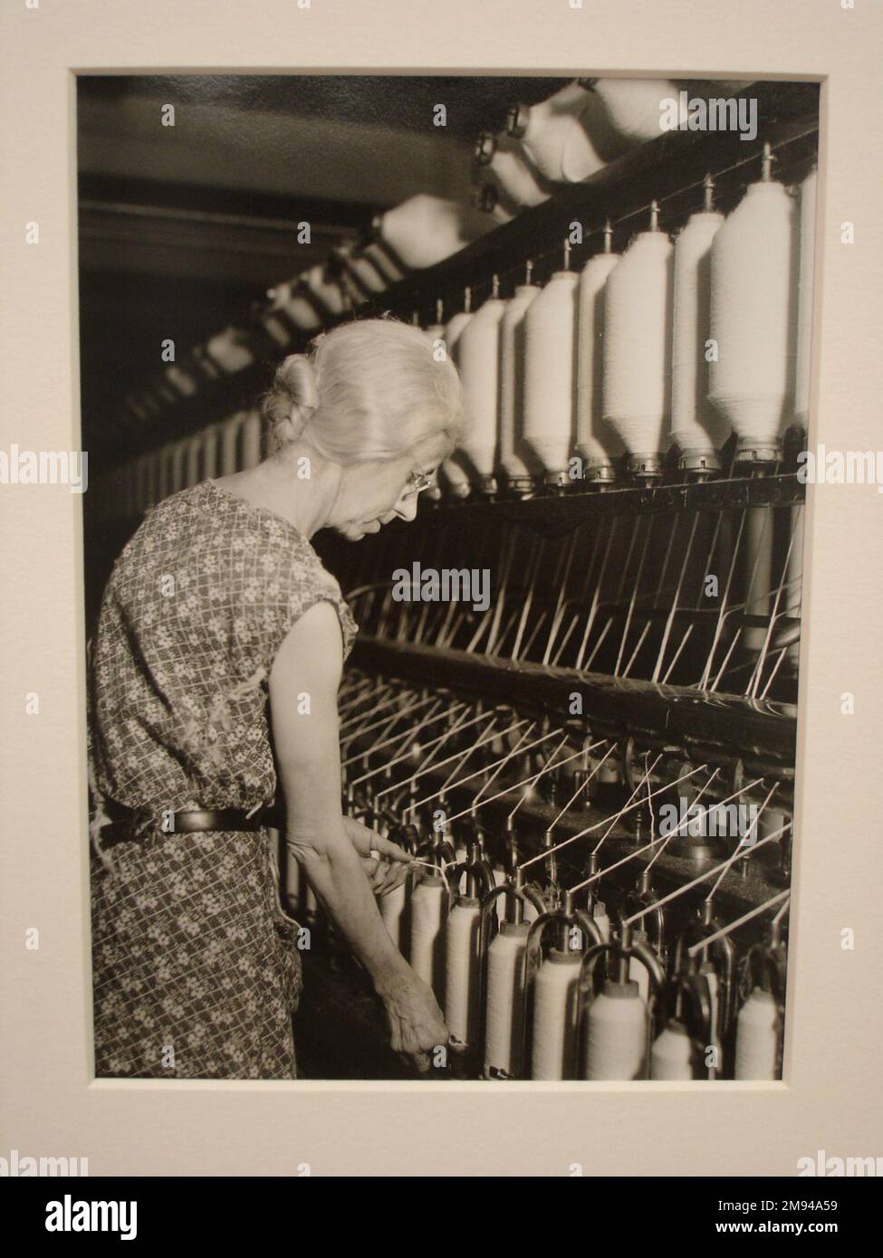 [Unbenannt] (Ältere Frau an der Bank of Thread Cylinders) Lewis Wickes Hine (Amerikaner, 1874-1940). , 1936-1937. Foto: Gelatine Silver, 7 1/4 x 4 3/4 cm (18,4 x 12,1 cm). Fotografie 1936-1937 Stockfoto