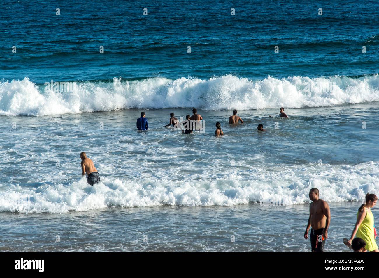 Eine Menge, die sich an einem sonnigen Morgen am Strand Farol da Barra ausruht Stockfoto