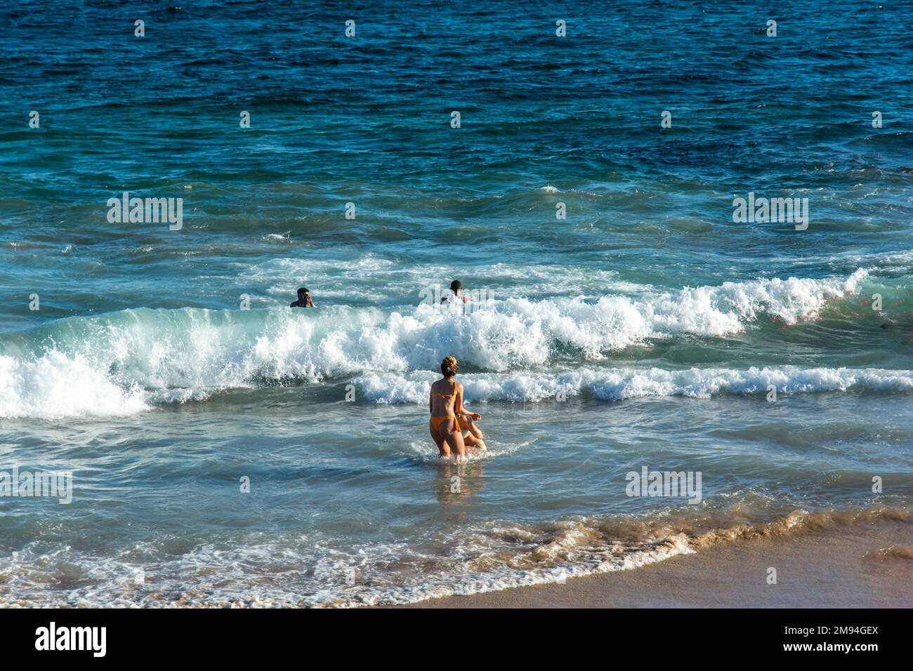 Eine Menge, die sich an einem sonnigen Morgen am Strand Farol da Barra ausruht Stockfoto
