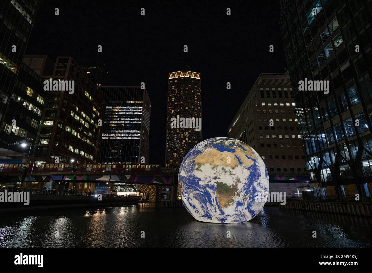 London, Großbritannien. 16. Januar 2023. Die schwimmende Erde, leichte Installation von Luke Jerram, im mittleren Dock an der Canary Wharf. Eine riesige magische Kugel schwebt im Wasser des Middle Dock an der Canary Wharf als Teil der Ausstellung des Winterlichterfestivals nach einer zweijährigen Pause aufgrund der COVID-Pandemie. Das Festival beginnt am Mittwoch, den 18. Januar, und endet am Samstag, den 28. Januar. Kredit: SOPA Images Limited/Alamy Live News Stockfoto