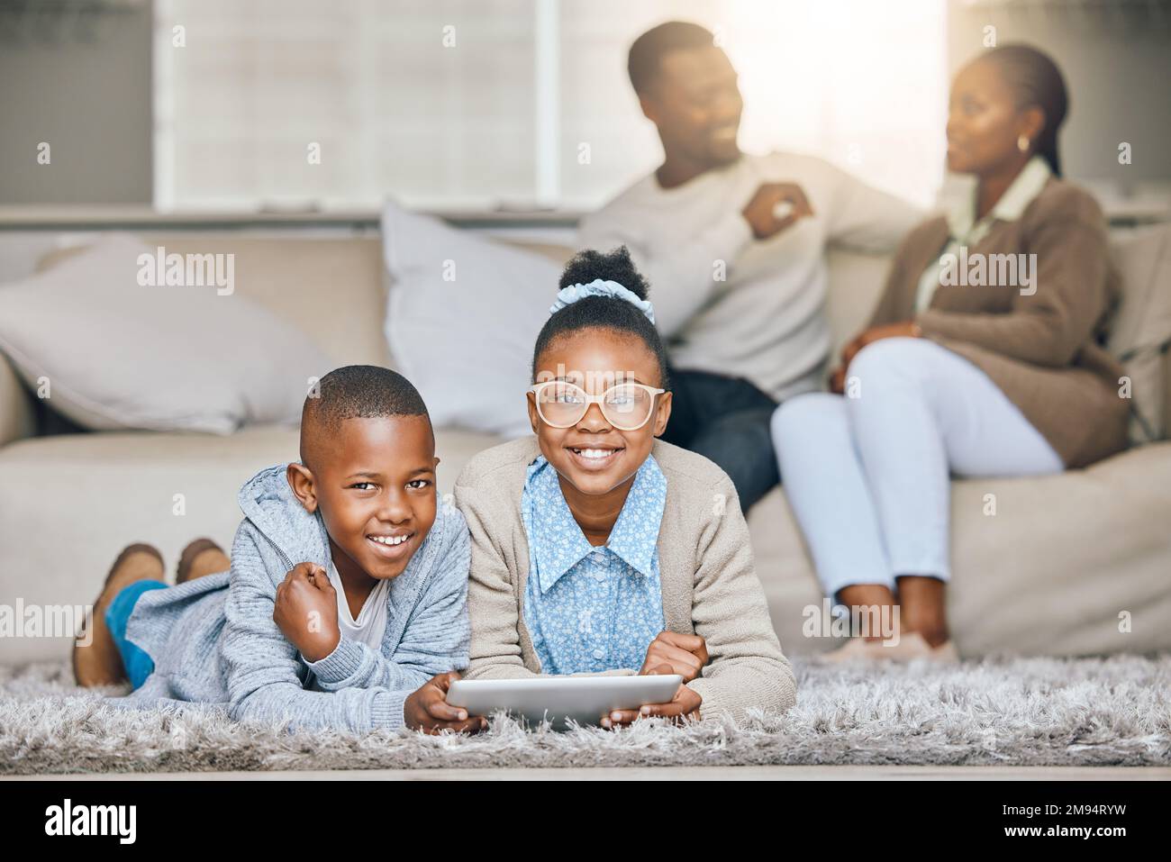 Es ist unsere Zeit für Tablets. Ein kleiner Bruder und eine kleine Schwester, die zu Hause zusammen ein digitales Tablet verwenden. Stockfoto