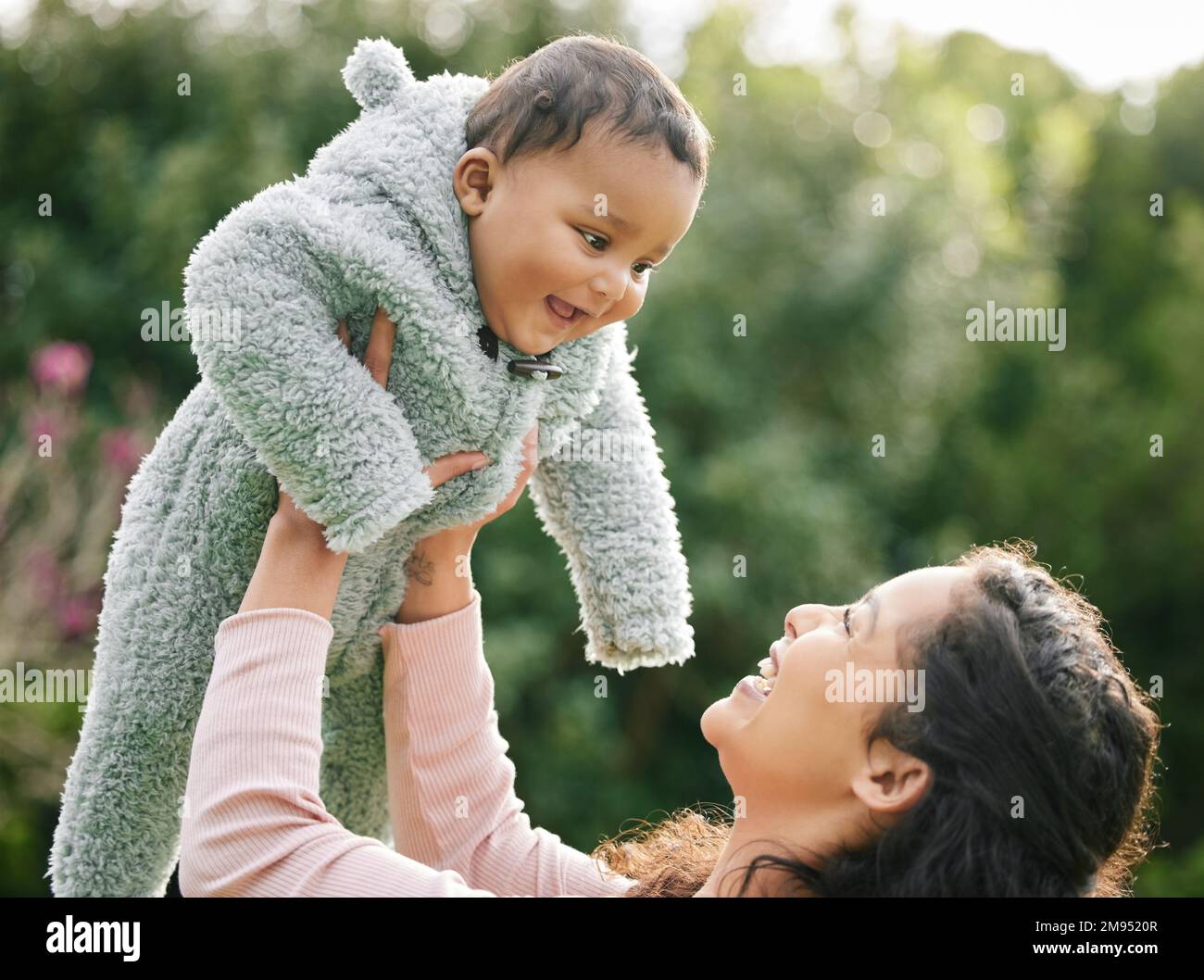 Ein Lächeln der Babys lehrt uns, ohne Grund glücklich zu sein. Eine Mutter, die sich draußen mit ihrem kleinen Sohn anfreundet. Stockfoto