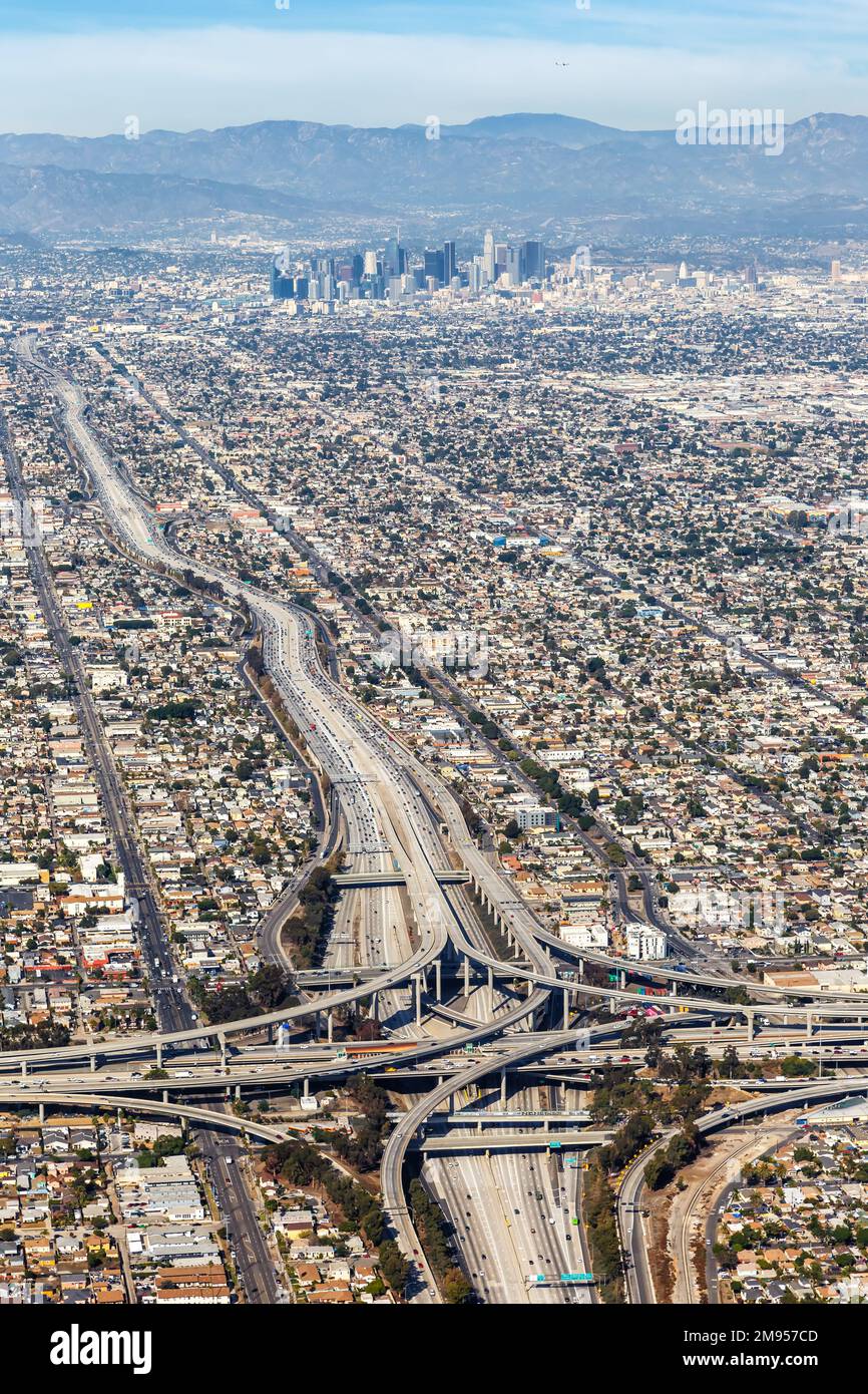 Luftaufnahme des Autobahnkreuzes Harbor und Century Freeway im Porträtformat mit der Innenstadt von Los Angeles, USA Stockfoto