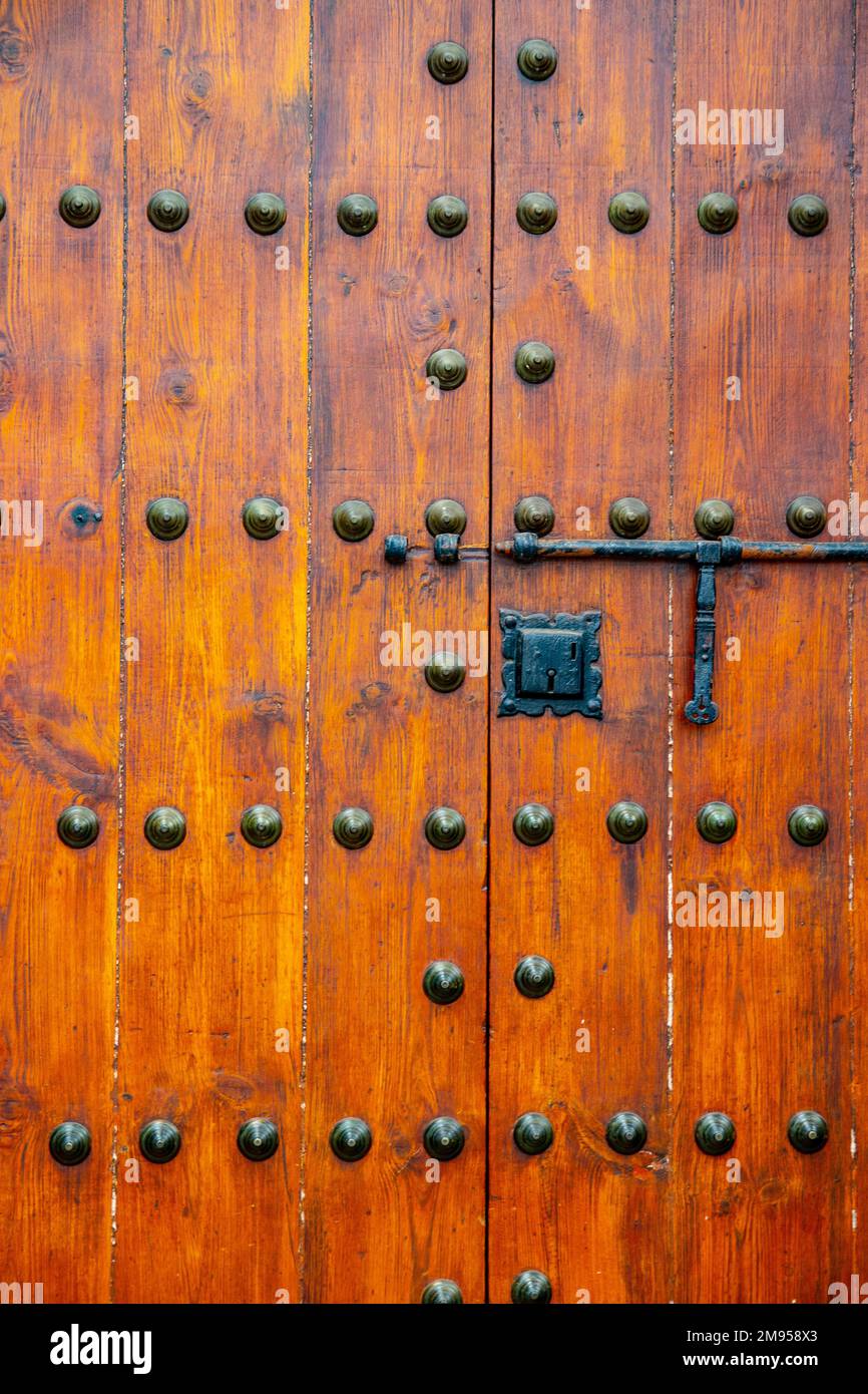 Details von einer alten riesigen Holztür in einer Steinwand einer Kirche. Stockfoto
