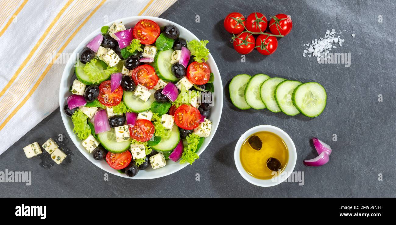 Griechischer Salat mit frischen Tomaten, Oliven und Fetakäse gesunde Lebensmittel Banner von oben auf einem Schiefer essen Stockfoto