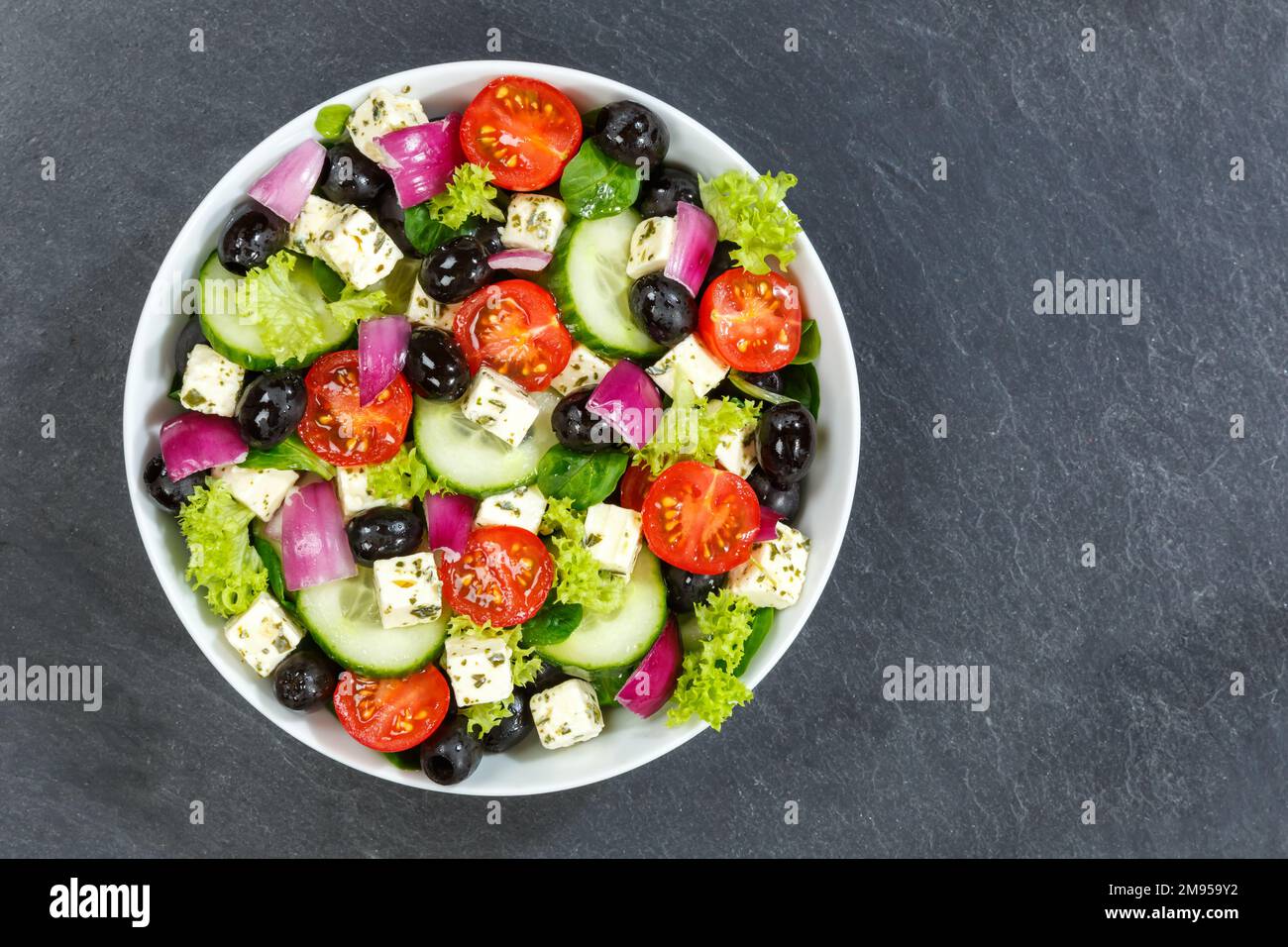 Griechischer Salat mit frischen Tomaten, Oliven und Fetakäse gesundes Essen von oben auf einem Schiefer mit Kopierraum essen Stockfoto