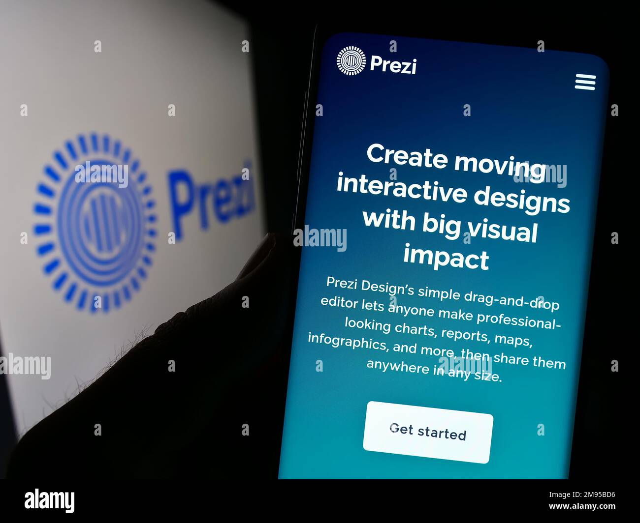 Person, die ein Mobiltelefon mit einer Webseite des ungarischen Softwareunternehmens Prezi Inc. Auf dem Bildschirm vor dem Logo hält. Konzentrieren Sie sich auf die Mitte des Telefondisplays. Stockfoto