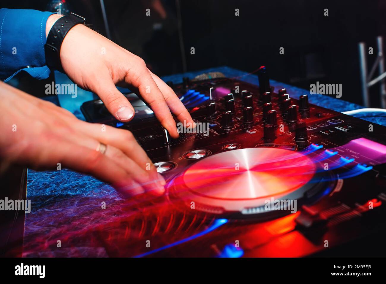 DJ mischen Musik mit professionellen Musikgeräten für CDs mit Tasten und Bedienelementen mit Lichteffekten Stockfoto