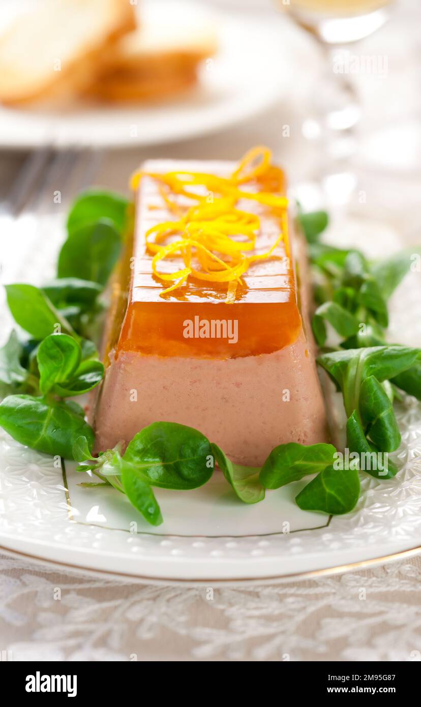 Köstliche Ostervorspeise zum Weihnachtsessen. Hähnchenleberpastete mit Gelee und frischem Maissalat auf weißem Gericht. Stockfoto