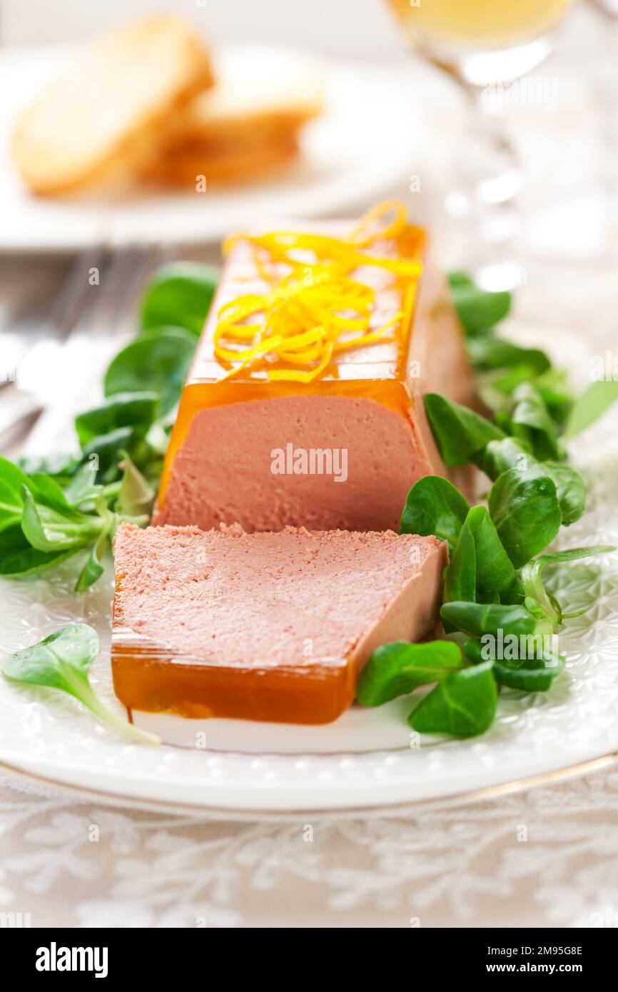 Köstliche Ostervorspeise zum Weihnachtsessen. Hähnchenleberpastete mit Gelee und frischem Maissalat auf weißem Gericht. Stockfoto