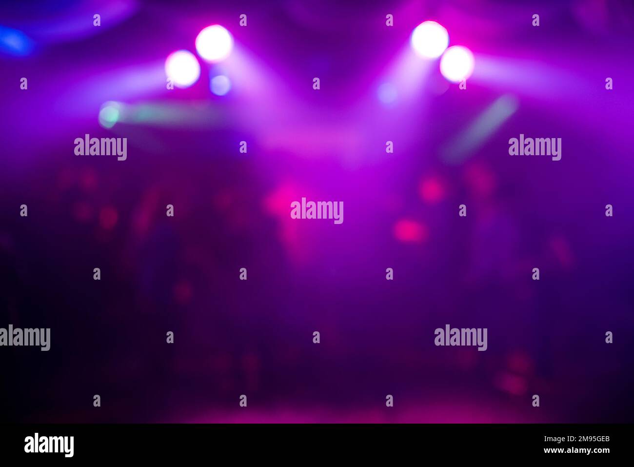 Unscharfer lilafarbener Hintergrund mit abstrakten Lichtflecken bei Nachtpartys Stockfoto