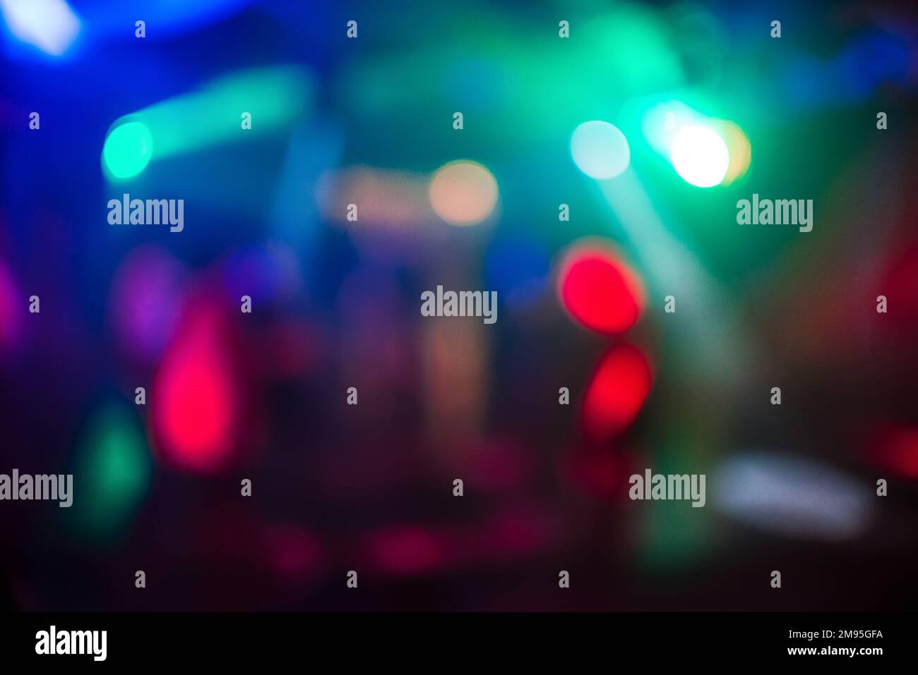 Verschwommener abstrakter Hintergrund von farbigen Lichtern in einem Nachtclub mit unscharfem Bokeh und hellen Punkten Stockfoto