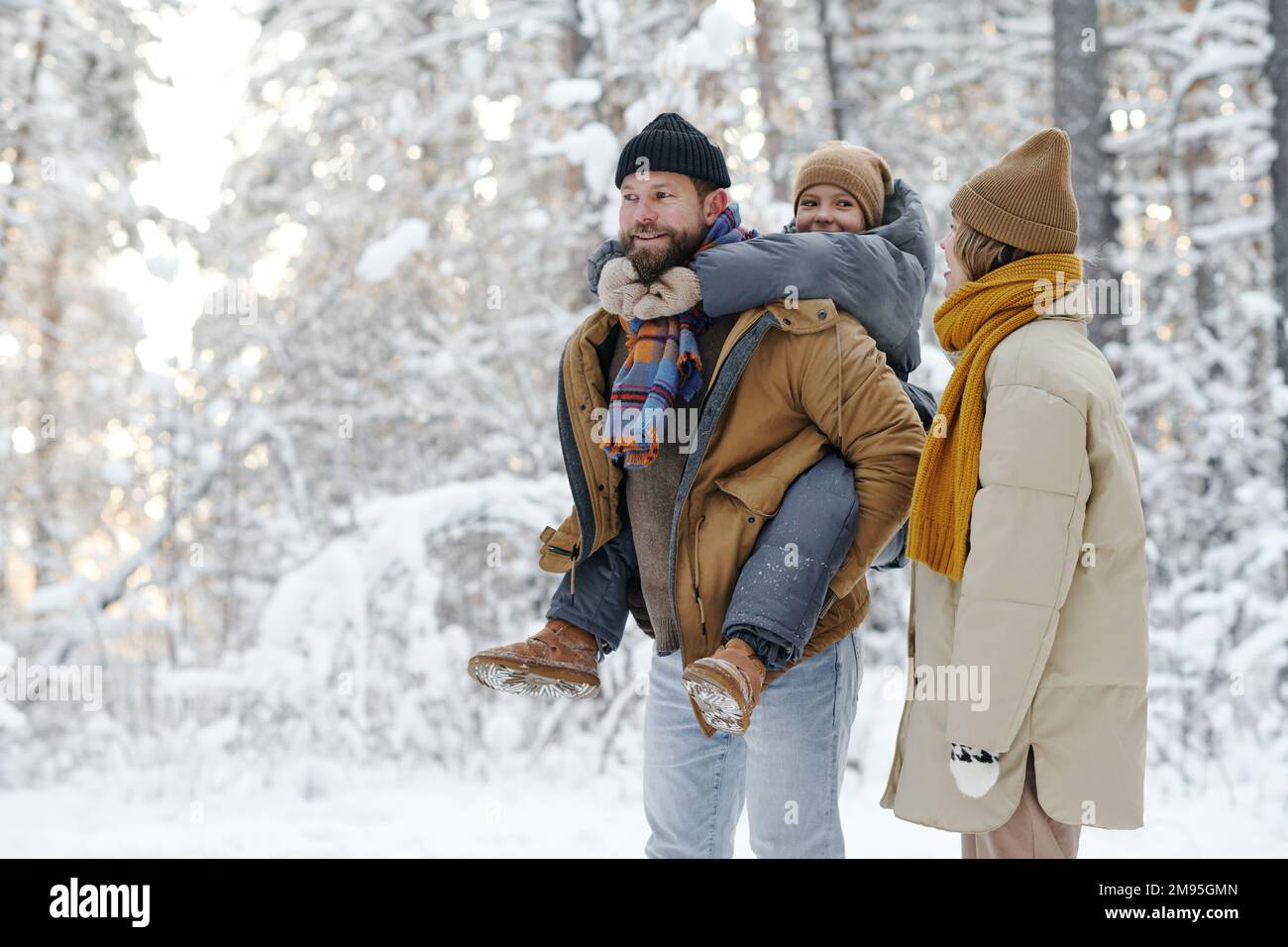 Die Familie hat Spaß mit ihrer Tochter im Freien, während sie im Wald spazieren geht Stockfoto