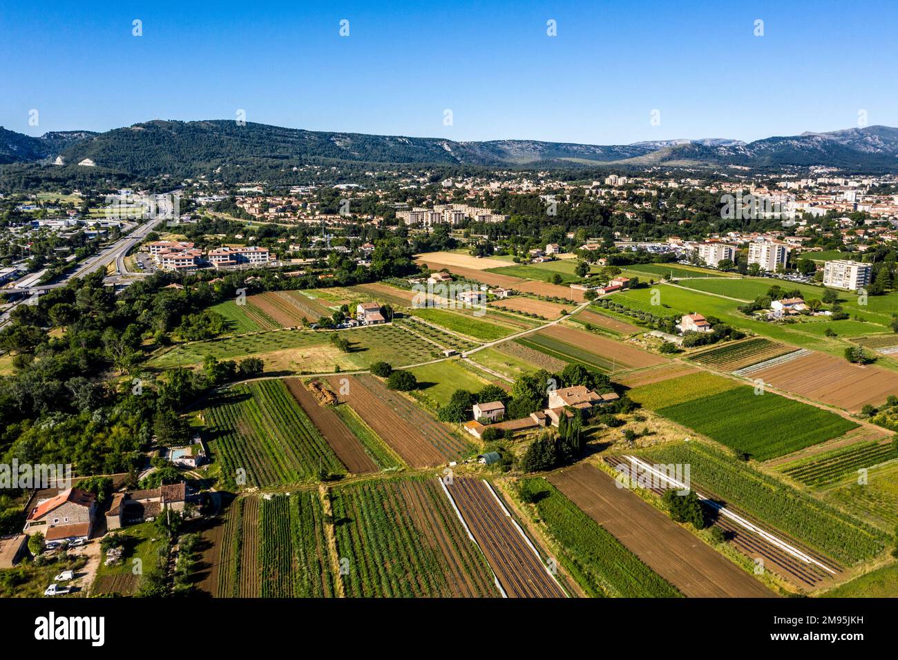 Aubagne (Südostfrankreich): Landwirtschaftsgebiete am Stadtrand mit Industriegebiet aus der Vogelperspektive Stockfoto