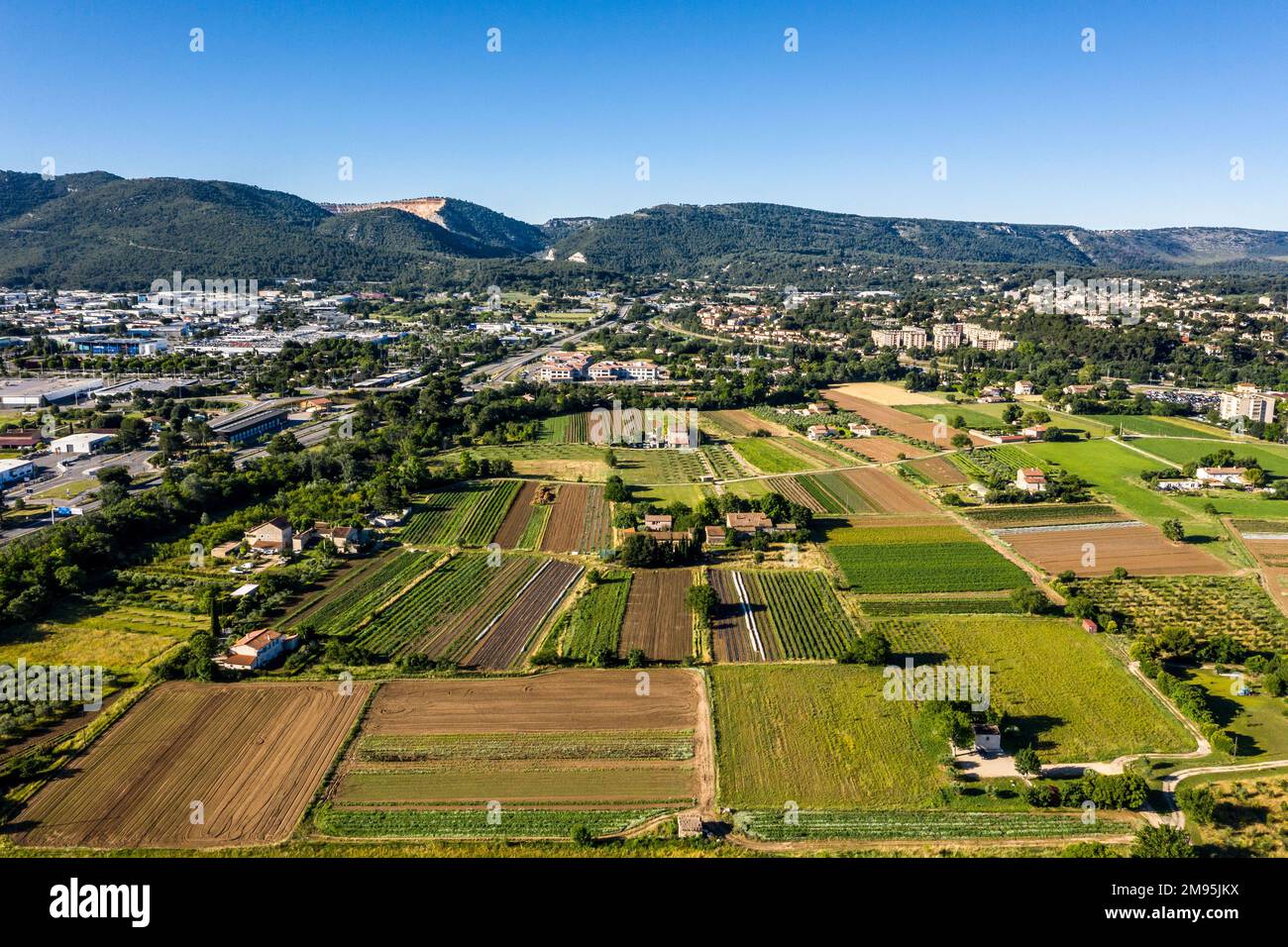 Aubagne (Südostfrankreich): Landwirtschaftsgebiete am Stadtrand mit Industriegebiet aus der Vogelperspektive Stockfoto