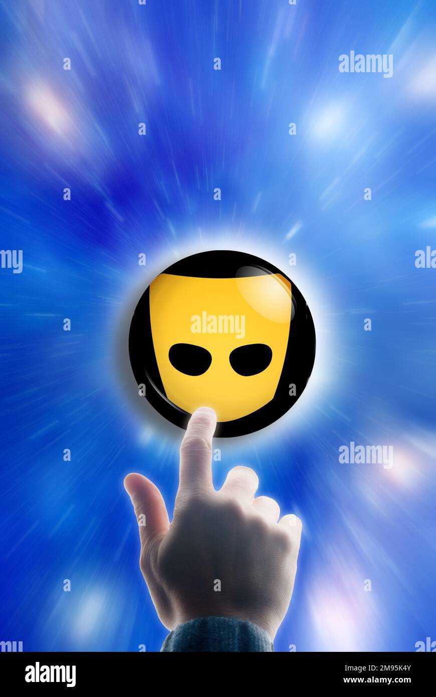 Man Finger berühren einen Knopf mit Logo von Grindr Stockfoto