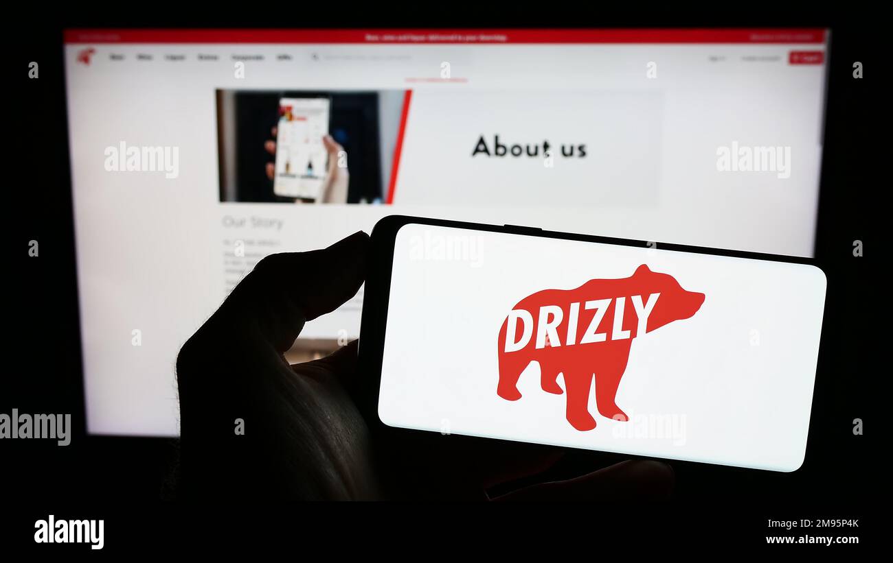 Person, die ein Handy mit dem Logo des US-Alkohollieferanten Drizly LLC auf dem Bildschirm vor der geschäftlichen Webseite hält. Konzentrieren Sie sich auf das Display des Telefons. Stockfoto