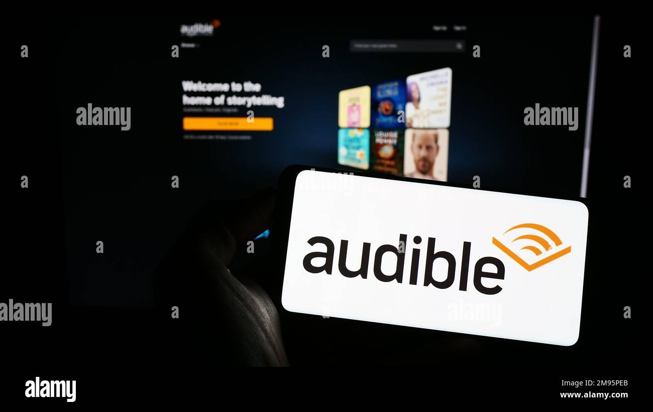 Person, die ein Smartphone mit dem Logo der US-amerikanischen Hörbuchfirma Audible Inc. Auf dem Bildschirm vor der Website hält. Konzentrieren Sie sich auf das Display des Telefons. Stockfoto
