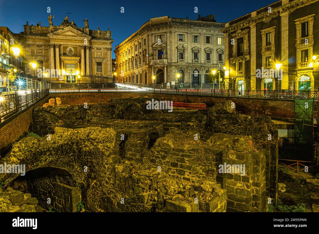 Ruinen unterhalb der Straßenebene eines breiten römischen Amphitheaters von 300 v. Chr. Im Zentrum von Catania im Licht der Dämmerung. Catania, Sizilien, Italien, Europa Stockfoto