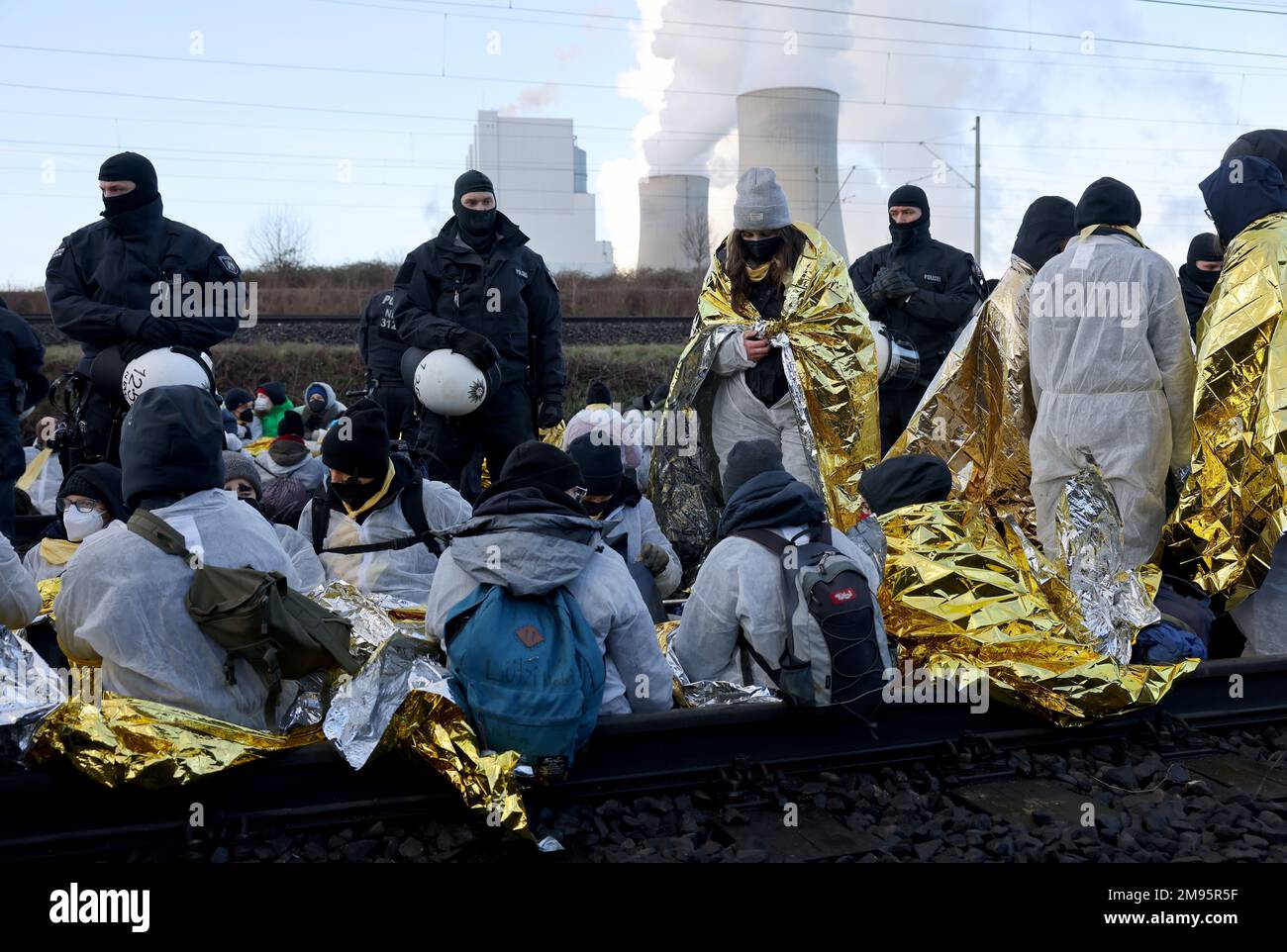 Neurath, Deutschland. 17. Januar 2023. Aktivisten blockieren Bahnstrecken zum Braunkohlekraftwerk Neurath II von RWE nach der Räumung von Lützerath setzten Kohlegegner ihre Proteste an mehreren Orten in Nordrhein-Westfalen am Dienstagmorgen fort. In der Nähe von Rommerskirchen besetzte eine Gruppe von Aktivisten die Bahngleise zum Kraftwerk Neurath, laut Polizei und RWE. Kredit: Oliver Berg/dpa/Alamy Live News Stockfoto