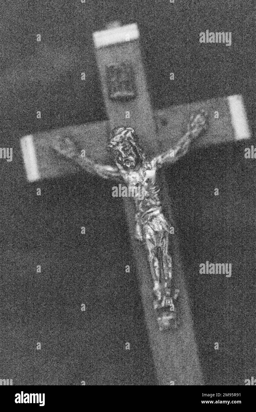 Monochromes Bild eines kleinen Holz- und Metallkruzifix-tragenden Jesus Christus Stockfoto