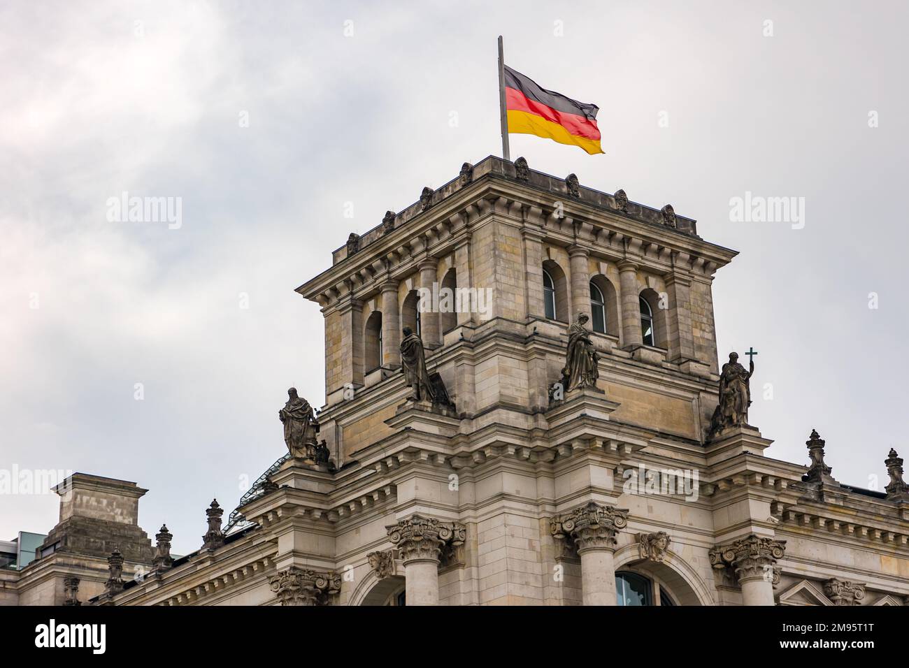 Die deutsche Flagge auf dem kunstvoll verzierten Turm des Reichstagsgebäudes im Regierungsbezirk Berlin Stockfoto
