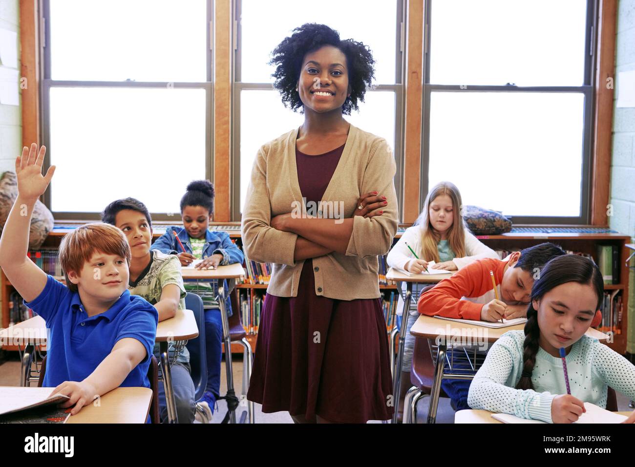 Porträt, Schülerfrage und schwarze Lehrerin im Klassenzimmer oder der Mittelschule. Bildung, verschränkte Arme oder ein Junge, der die Hand hebt, um Fragen zu beantworten Stockfoto