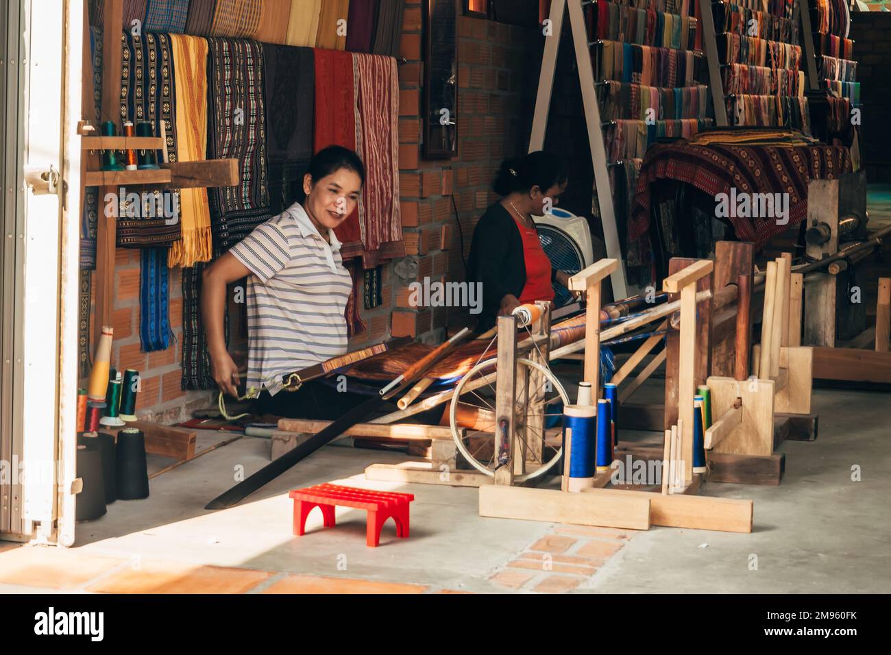 MUI NE, VIETNAM - 6. MÄRZ 2017: Weberinnen arbeiten in der Werkstatt an traditionellen Webstühlen für Seide Stockfoto